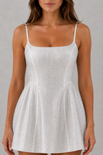 White patterned dress worn by a model on a gray background
