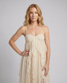 Woman wearing a beige dress against a plain background