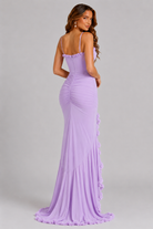 Woman wearing a purple evening gown with a plain background
