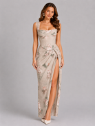 Woman wearing a floral dress with a slit on a gray background