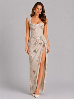 Woman wearing a floral dress with a slit on a gray background