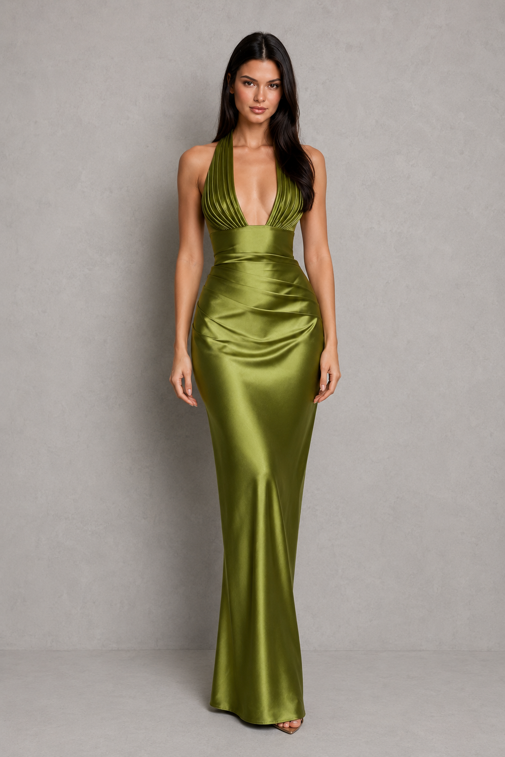 Woman wearing a green satin gown against a gray background