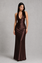 Woman wearing a brown satin evening gown against a gray background
