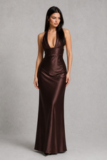 Woman wearing a brown satin evening gown against a gray background