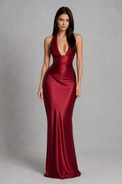 Woman wearing a red evening gown against a gray background