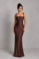 Woman wearing a brown evening gown against a gray background
