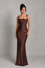 Woman wearing a brown evening gown against a gray background