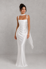 Woman wearing a white dress against a gray background