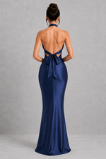 Navy blue evening gown with open back on a gray background