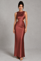 Woman wearing a burgundy satin gown against a gray background