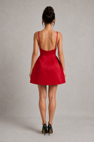 Red dress worn by a person on a plain background