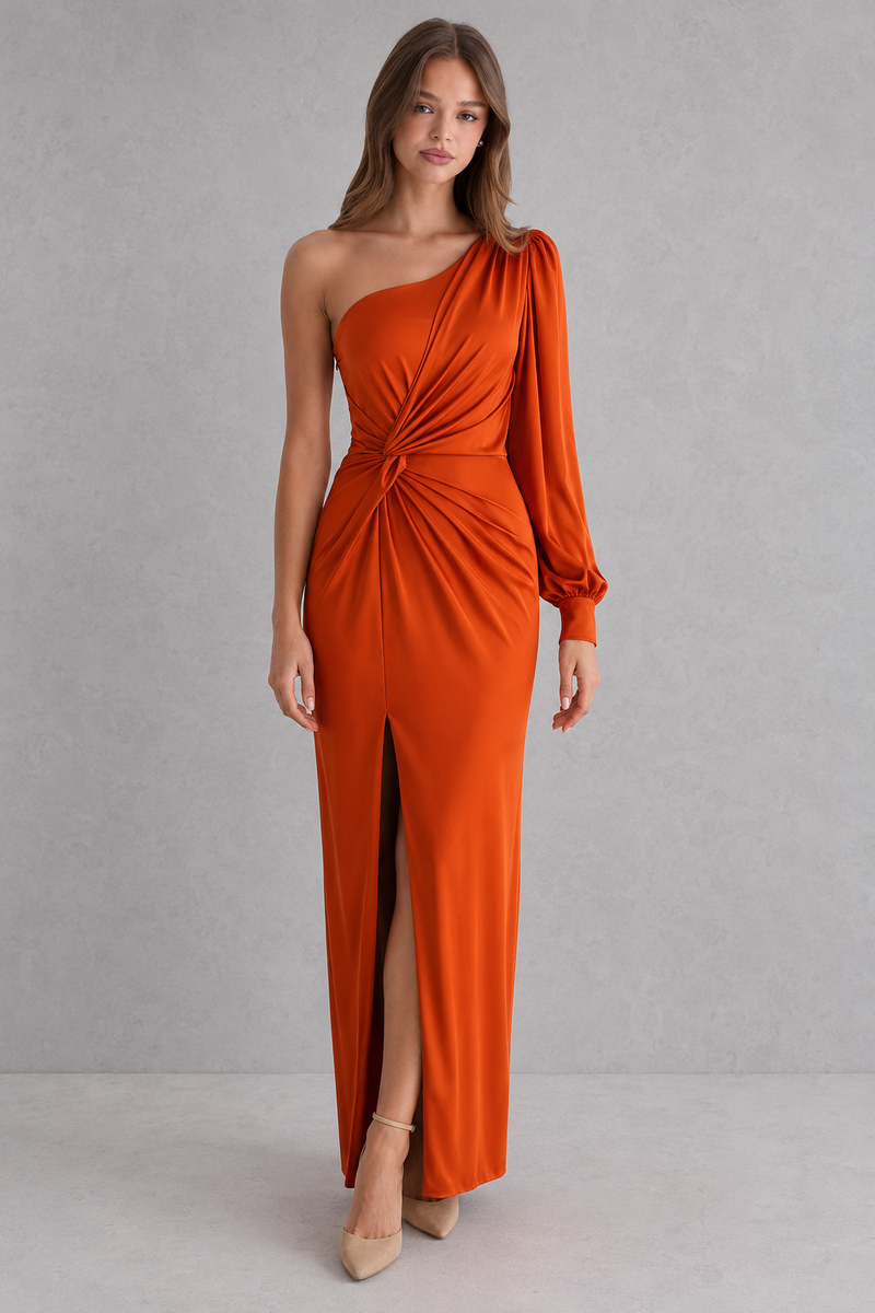 Woman wearing a long orange dress with a gray background