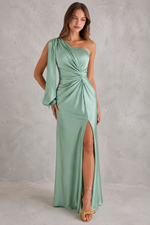 Woman wearing a mint green one-shoulder dress with a slit on a gray background