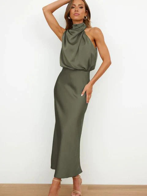 Woman wearing an olive green halter neck dress on a white background