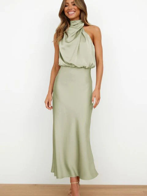 Woman wearing a green halter neck dress against a white background