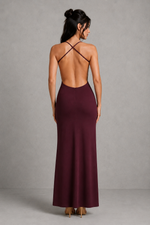 Woman wearing a burgundy dress with thin straps against a gray background
