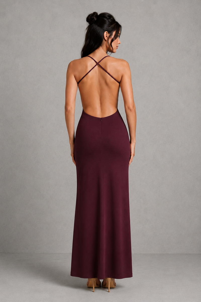 Woman wearing a burgundy dress with thin straps against a gray background