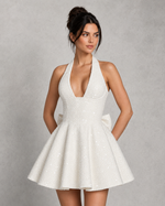 Woman wearing a white dress against a gray background