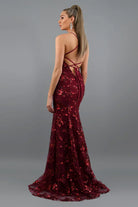 Burgundy sequin evening gown with a backless design on a gray background
