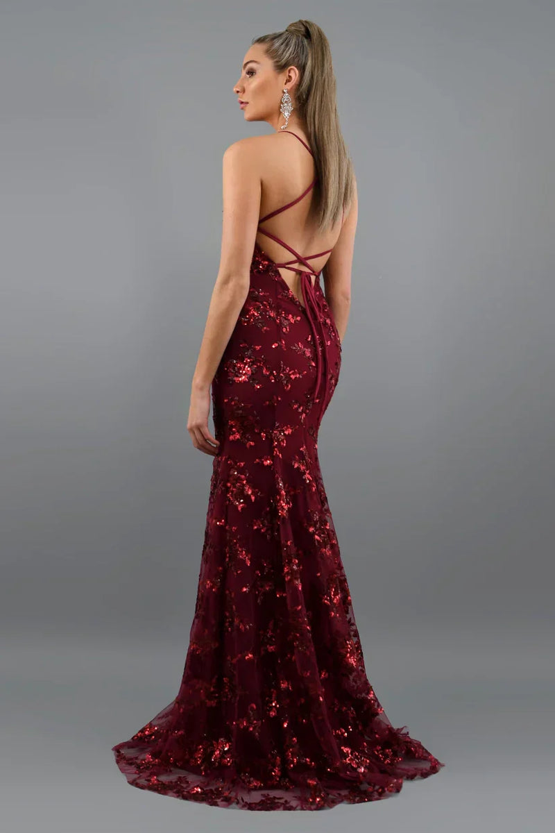 Burgundy sequin evening gown with a backless design on a gray background