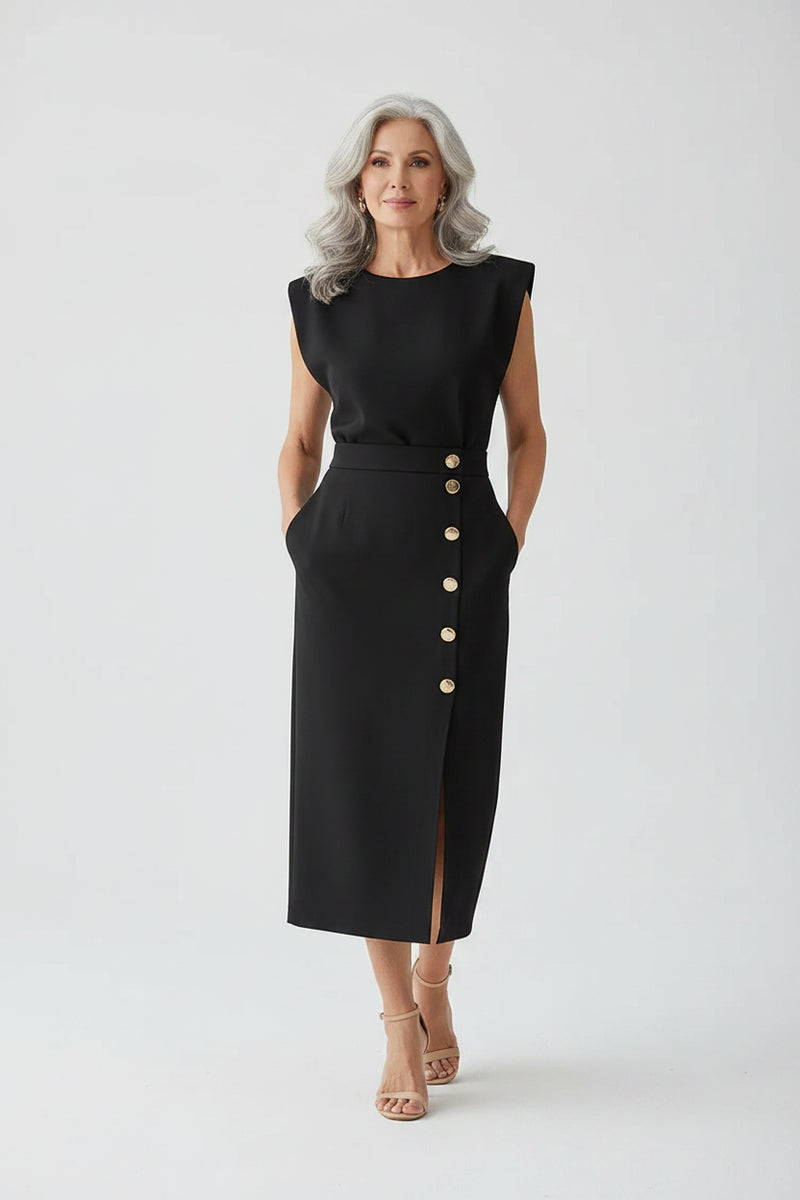 Woman wearing a black dress with buttons standing in a modern interior setting.