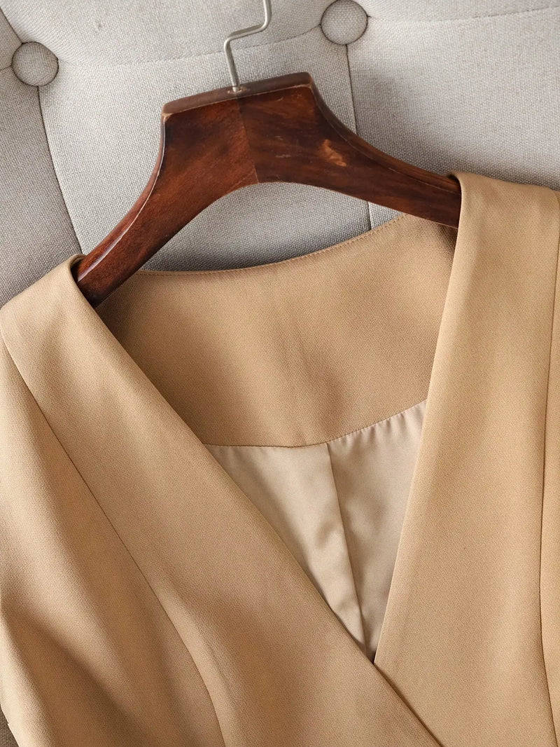 Beige coat on a wooden hanger against a neutral background