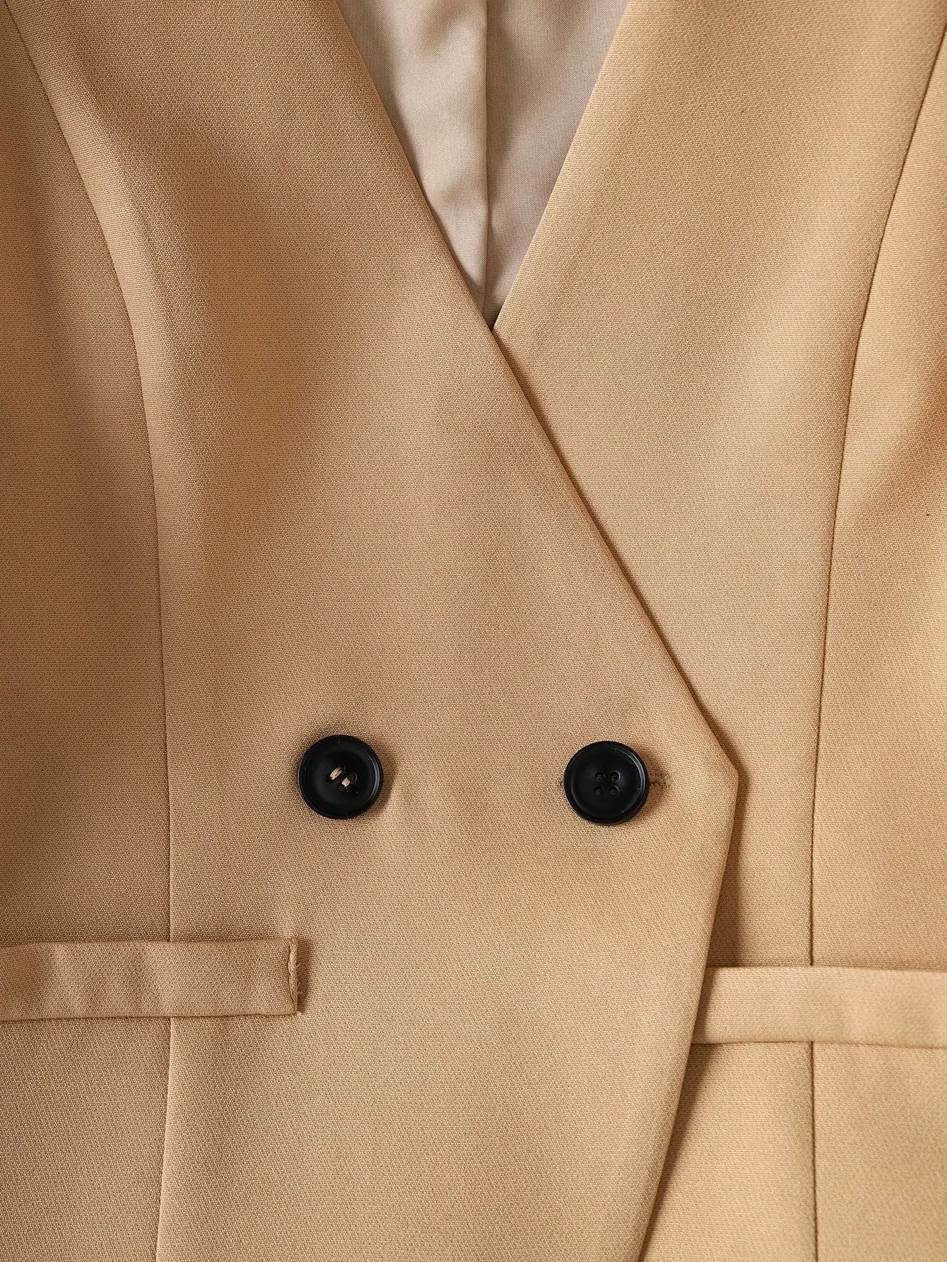 Close-up of a beige trench coat with black buttons