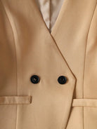 Close-up of a beige trench coat with black buttons