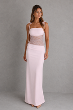 Woman wearing a light pink dress with a gray background
