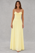 Woman wearing a yellow dress against a gray background