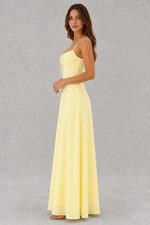 Woman wearing a yellow dress against a gray background