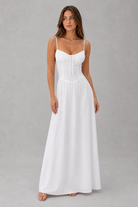 Woman wearing a white dress against a gray background