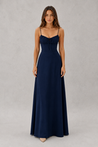 Woman wearing a navy blue dress on a gray background