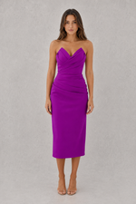 Woman wearing a strapless purple dress against a gray background