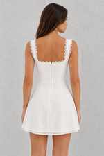 White dress with lace details on a gray background