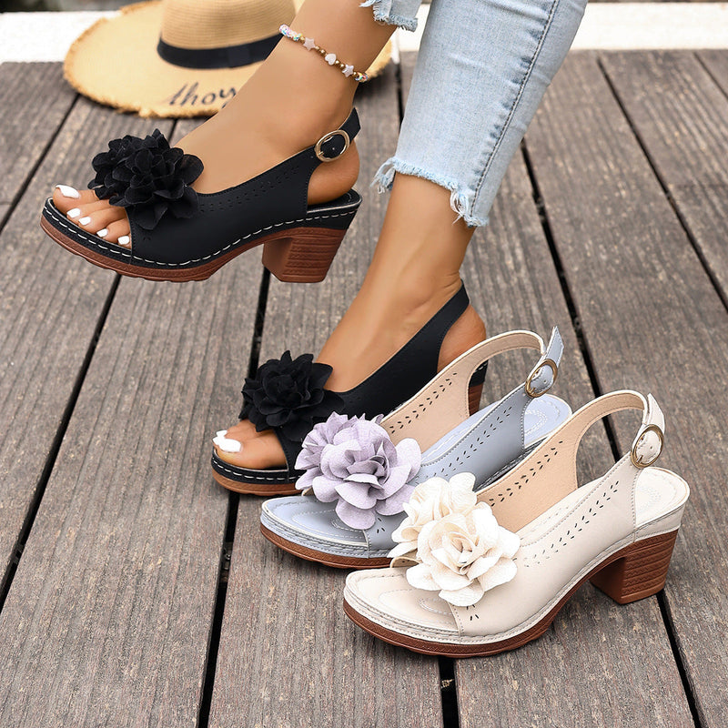 Black and white floral sandals on a wooden floor