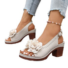 White sandals with floral designs on a white background