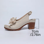 Beige sandal with wooden heel and flower detail on a light gray background