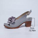 Gray sandal with a flower detail on a light gray background