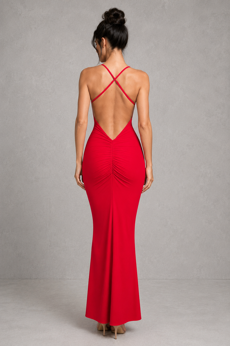 Woman wearing a red evening gown with a backless design on a gray background
