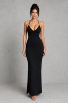 Woman wearing a black evening gown against a gray background