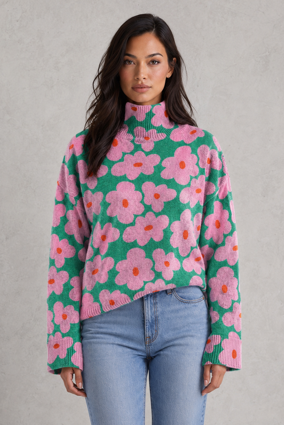 Woman wearing a green sweater with pink floral pattern against a gray background