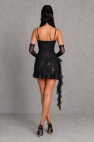 Black lace dress with sheer sleeves on a gray background