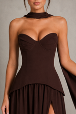 Brown strapless dress with a high slit on a neutral background