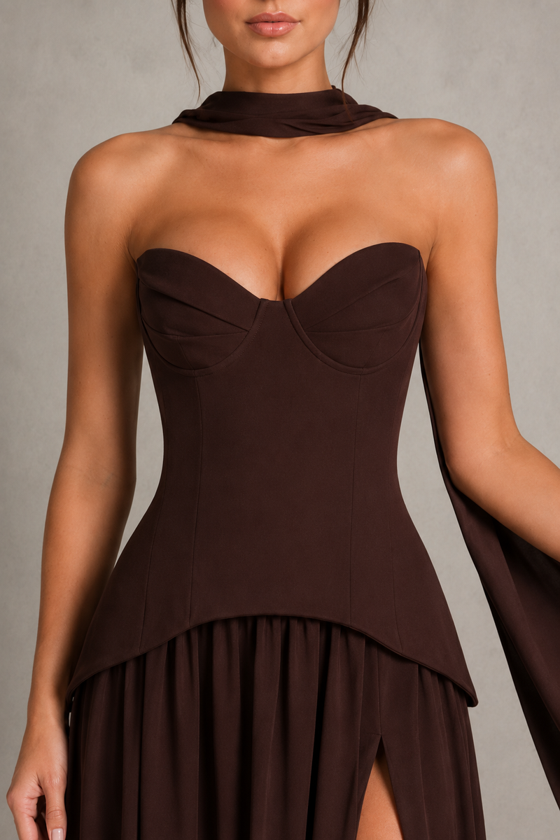 Brown strapless dress with a high slit on a neutral background