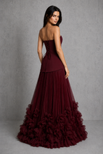 Women’s cherry lacquer strapless corset gown with a lace-up back, pleated full skirt, and handcrafted floral appliqué hem