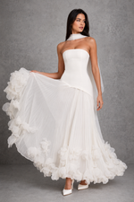 Women’s cherry lacquer strapless corset gown with a lace-up back, pleated full skirt, and handcrafted floral appliqué hem