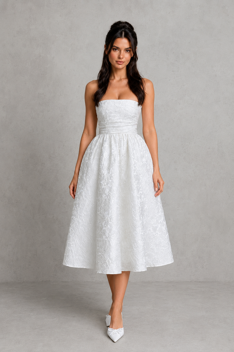 Woman wearing a white strapless dress against a gray background