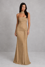 Woman wearing a beige strapless gown against a plain background