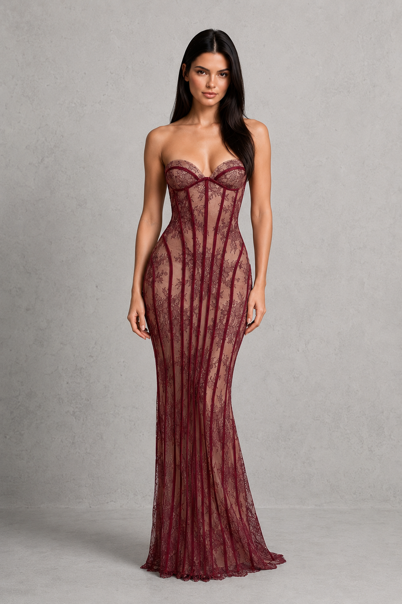 Woman wearing a burgundy strapless gown against a gray background